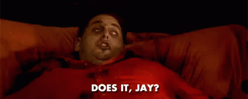 A Man In A Red Shirt Is Laying On A Bed And Says Does It Jay GIF