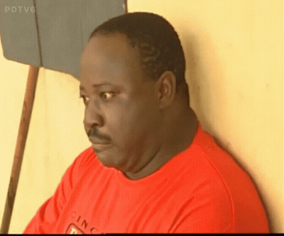 A Man In A Red Shirt Is Leaning Against A Wall With Pdtv6 On The Bottom Right GIF