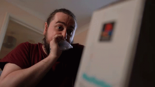 A Man In A Red Shirt Is Looking At A Box With A Sticker That Says Pizza Hut GIF