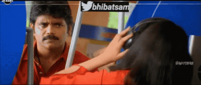 A Man In A Red Shirt Is Looking At A Woman In A Red Shirt With Headphones On GIF