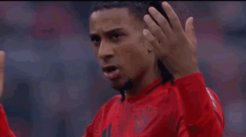 A Man In A Red Shirt Is Making A Gesture With His Finger GIF