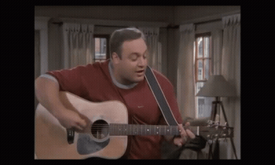 A Man In A Red Shirt Is Playing A Guitar GIF