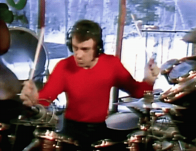A Man In A Red Shirt Is Playing Drums . GIF