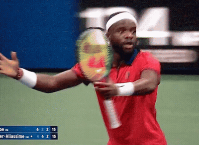 A Man In A Red Shirt Is Playing Tennis GIF