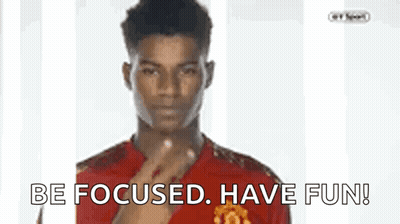 A Man In A Red Shirt Is Pointing At The Camera With The Words Be Focused Have Fun Below Him GIF
