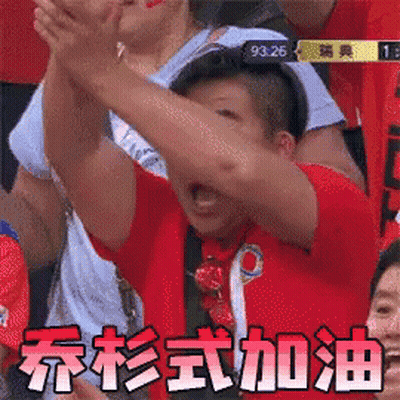 A Man In A Red Shirt Is Raising His Arms In The Air In A Crowd Of People . GIF
