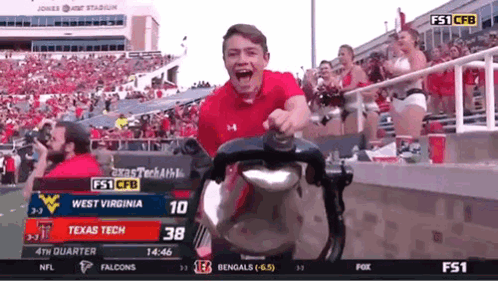 A Man In A Red Shirt Is Riding A Stroller In A Stadium . GIF