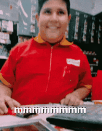 A Man In A Red Shirt Is Sitting At A Table With A Keyboard And A Calculator GIF