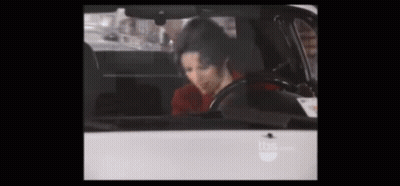A Man In A Red Shirt Is Sitting In A Car . GIF