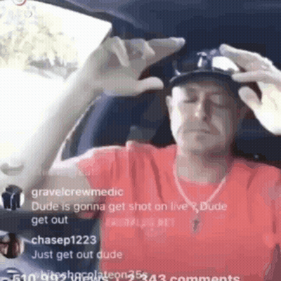 A Man In A Red Shirt Is Sitting In A Car With His Eyes Closed And A Hat On . GIF