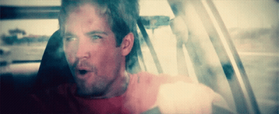 A Man In A Red Shirt Is Sitting In A Car With His Mouth Open GIF