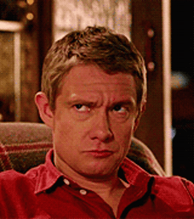 A Man In A Red Shirt Is Sitting In A Chair GIF