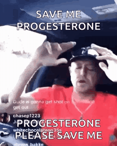 A Man In A Red Shirt Is Sitting In The Driver 'S Seat Of A Car And Holding His Head . GIF