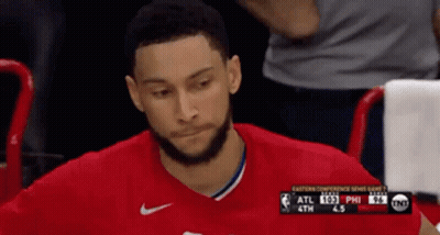 A Man In A Red Shirt Is Sitting In The Stands Watching A Game GIF