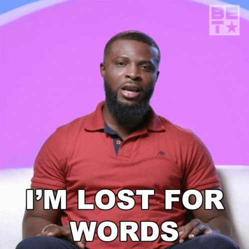 A Man In A Red Shirt Is Sitting On A Couch And Says I 'M Lost For Words GIF