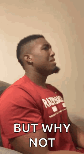 A Man In A Red Shirt Is Sitting On A Couch With His Eyes Closed And Says `` But Why Not '' . GIF