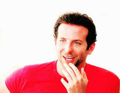 A Man In A Red Shirt Is Smiling And Covering His Mouth GIF