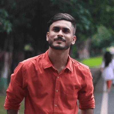 A Man In A Red Shirt Is Smiling And Looking Up GIF