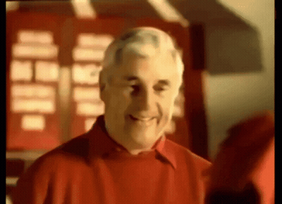 A Man In A Red Shirt Is Smiling In A Blurry Photo GIF