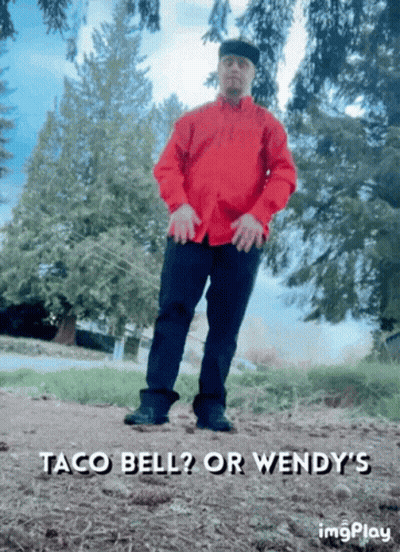 A Man In A Red Shirt Is Standing In A Field With The Words Taco Bell Or Wendy 'S Written Below Him GIF