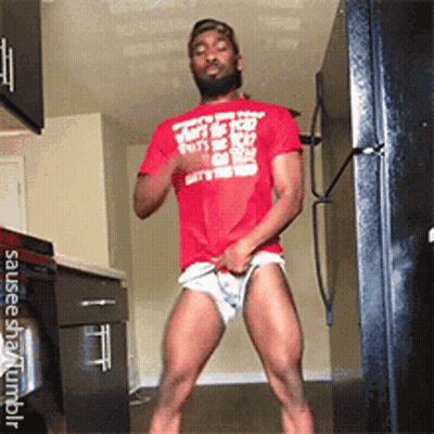A Man In A Red Shirt Is Standing In A Kitchen With His Pants Down . GIF