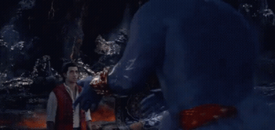 A Man In A Red Shirt Is Standing In Front Of A Blue Monster GIF
