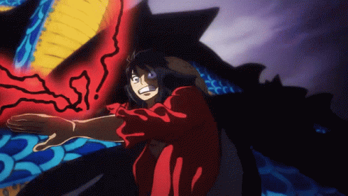 A Man In A Red Shirt Is Standing In Front Of A Giant Monster . GIF