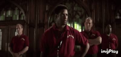 A Man In A Red Shirt Is Standing In Front Of A Group Of Men And Says `` We Will Be Perfect ... '' . GIF