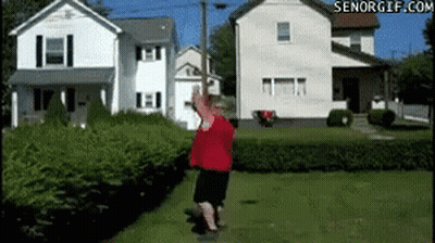 A Man In A Red Shirt Is Standing In Front Of A House With Senorgif.com In The Corner GIF