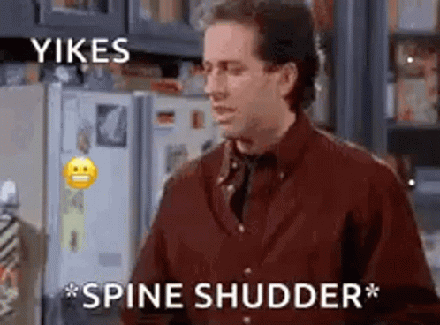 A Man In A Red Shirt Is Standing In Front Of A Refrigerator . GIF