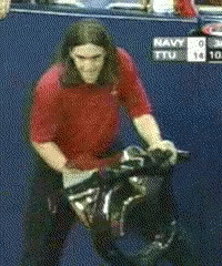 A Man In A Red Shirt Is Standing In Front Of A Scoreboard That Says Navy 0 Ttu 10 GIF