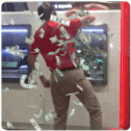 A Man In A Red Shirt Is Standing In Front Of An Atm Machine Filled With Money . GIF