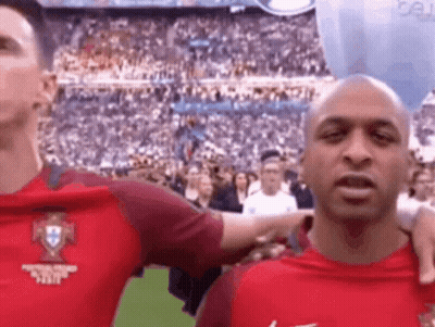 A Man In A Red Shirt Is Standing Next To Another Man In A Red Shirt . GIF