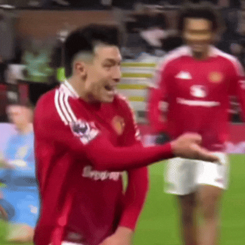 A Man In A Red Shirt Is Standing On A Soccer Field With His Hands In His Pockets . GIF