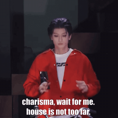 A Man In A Red Shirt Is Standing With His Arms Outstretched And Says " Charisma Wait For Me House Is Not Too Far " GIF