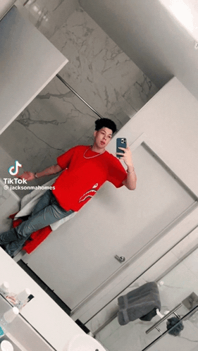 A Man In A Red Shirt Is Taking A Picture Of Himself GIF