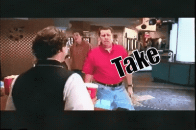 A Man In A Red Shirt Is Talking To A Man In A Black Vest With The Word Take Written On It GIF