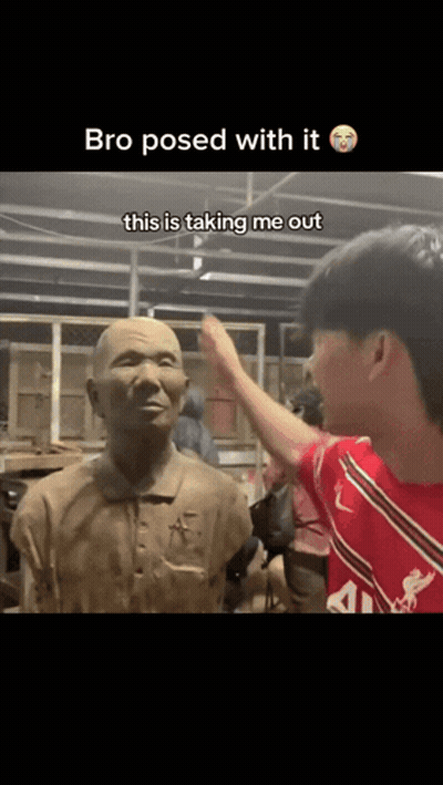 A Man In A Red Shirt Is Touching A Statue With The Caption " Bro Posed With It " GIF