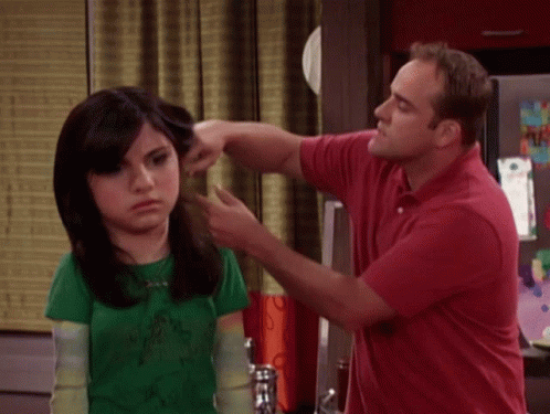 A Man In A Red Shirt Is Touching A Woman In A Green Shirt GIF