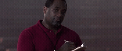A Man In A Red Shirt Is Writing In A Notebook . GIF