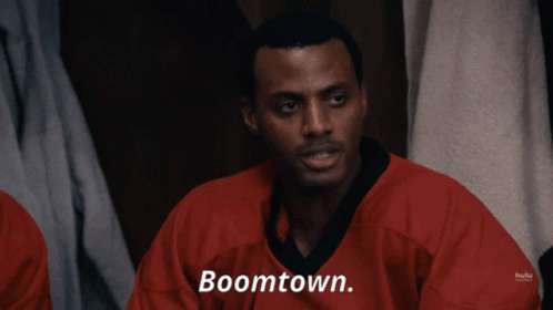 A Man In A Red Shirt Says Boomtown On The Screen GIF