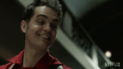 A Man In A Red Shirt Smiles In Front Of A Netflix Logo GIF