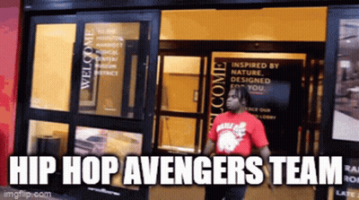 A Man In A Red Shirt Standing In Front Of A Building With The Words Hip Hop Avengers Team GIF
