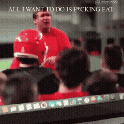 A Man In A Red Shirt Stands In Front Of A Group Of People And Says All I Want To Do Is Fucking Eat GIF
