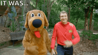 A Man In A Red Shirt Stands Next To A Stuffed Dog With The Words " It Was " Written On The Bottom GIF