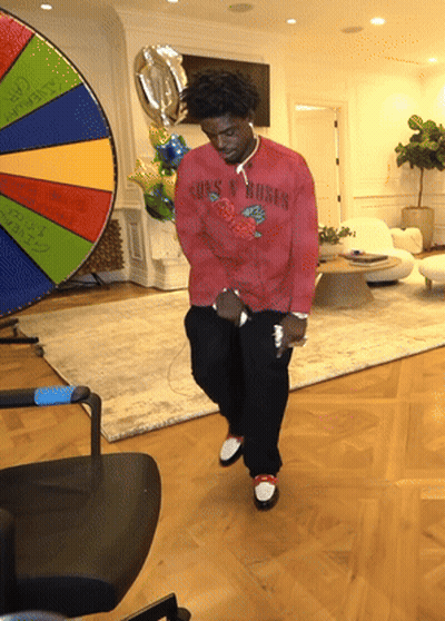 A Man In A Red Shirt That Says Guns N Roses Is Dancing GIF