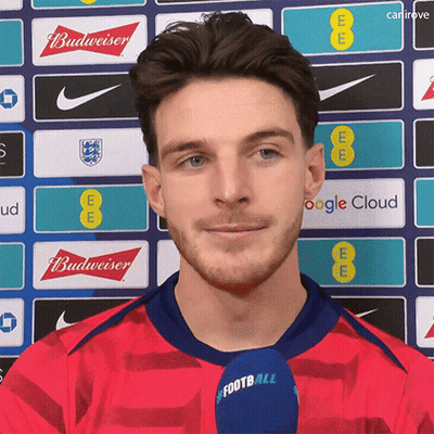 A Man In A Red Shirt With A Microphone That Says Football On It GIF