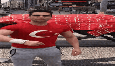 A Man In A Red Shirt With A Star And Crescent Moon On It GIF