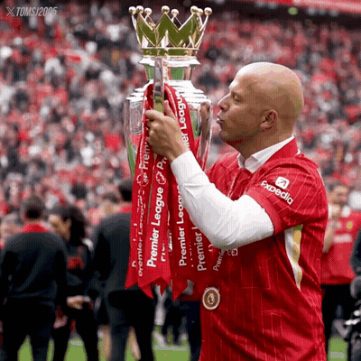 A Man In A Red Shirt With Expedia On It Kisses The Trophy GIF