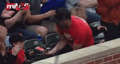 A Man In A Red Shirt With The Letter G On It Is Sitting In A Stadium GIF